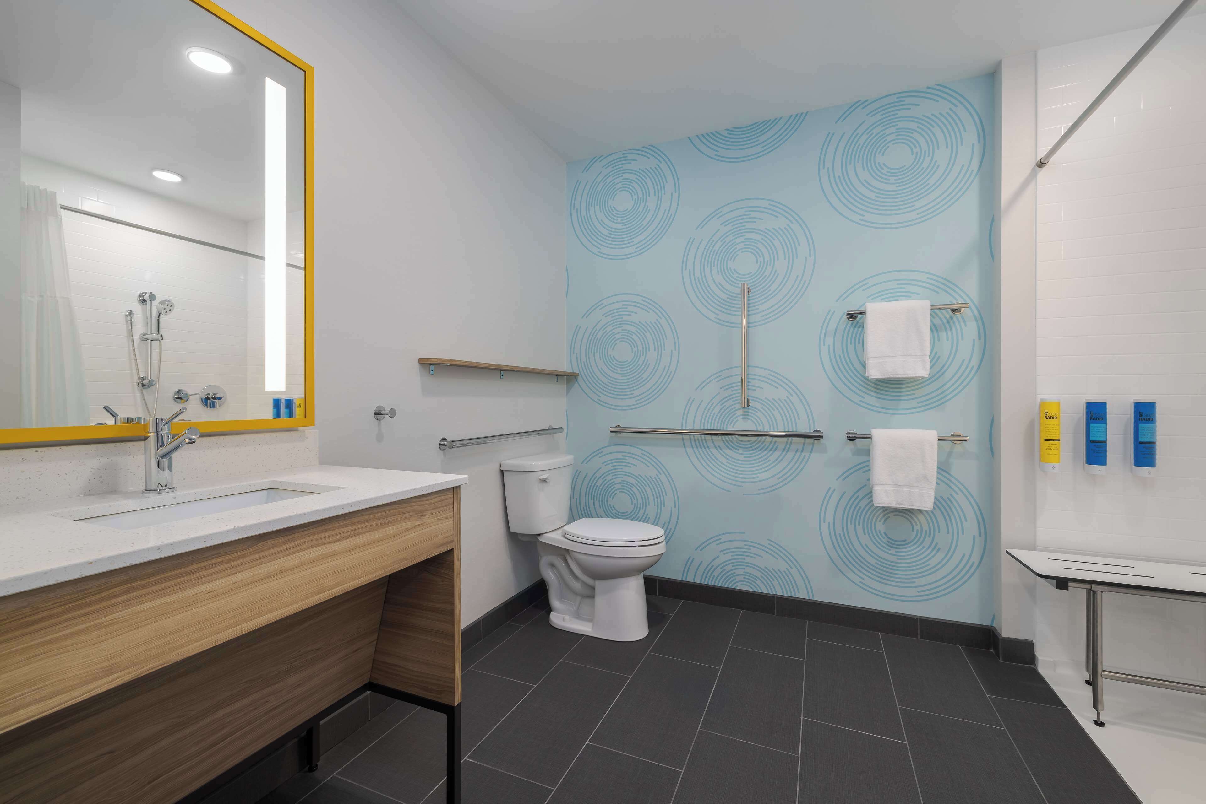 A modern bathroom with a white sink, a toilet, and a shower area.