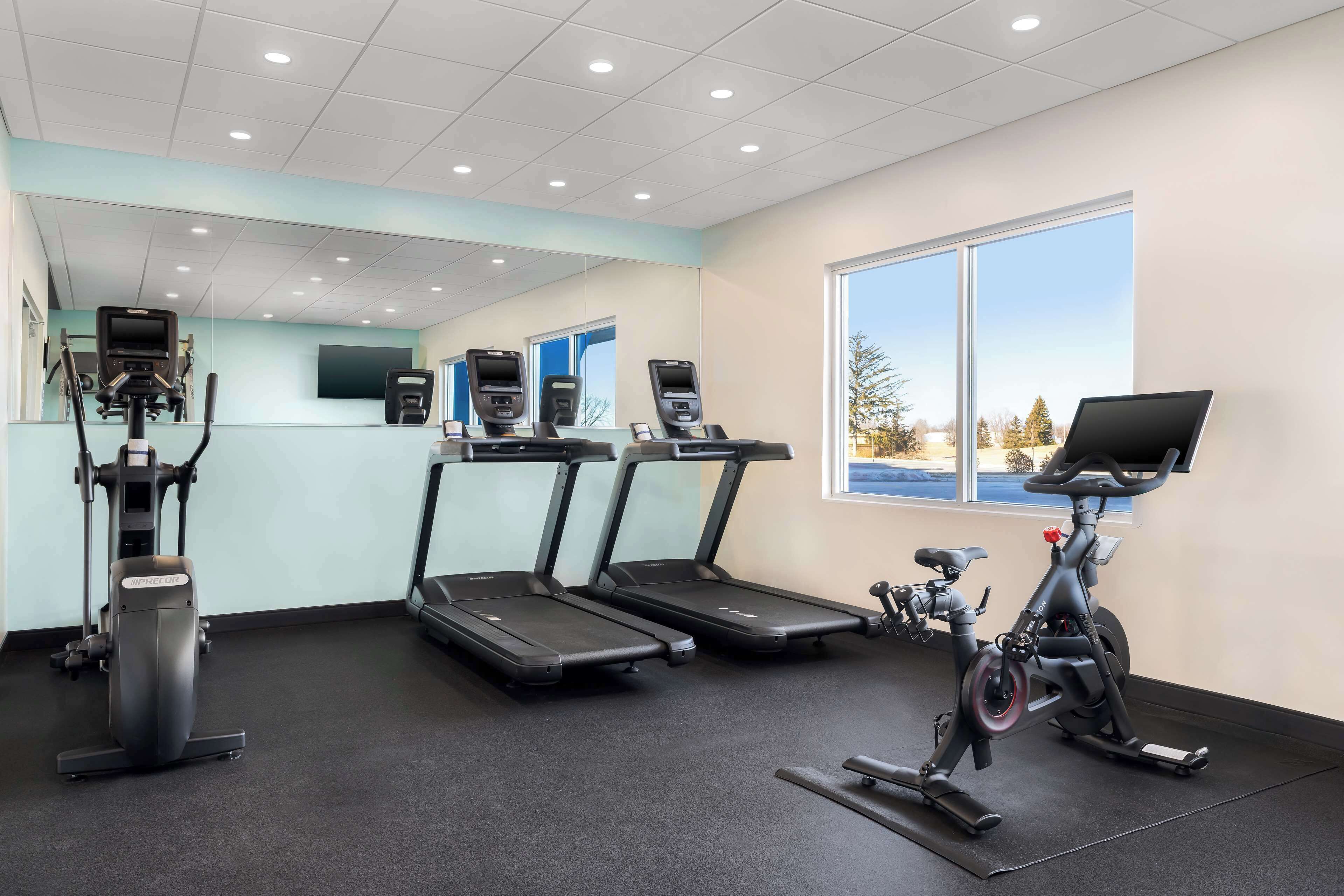 A gym with treadmills, an elliptical, and a stationary bike.