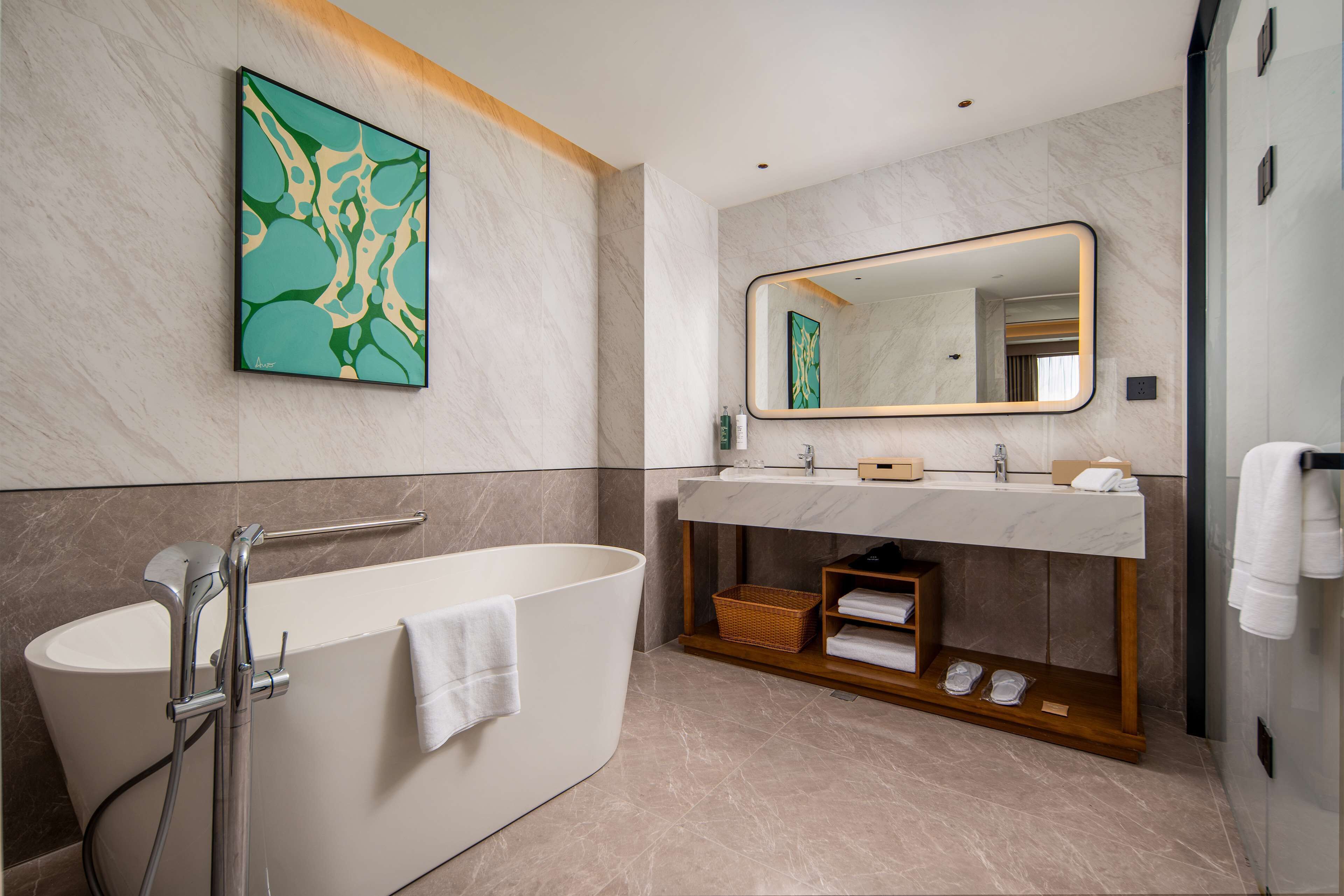 Une salle de bain moderne avec une baignoire sur pieds, un grand miroir et un mur en marbre.