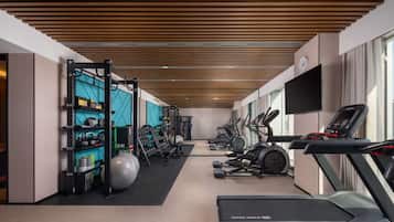 Una palestra moderna con diverse attrezzature per l'allenamento, tra cui tapis roulant, cyclette e macchinari per pesi.
