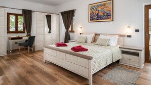 A bedroom with a bed, desk, chair, and a painting on the wall. - Beautiful Villa in Nature (Groznjan)