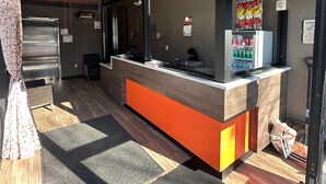 Un espace d’accueil comprenant un comptoir, une porte et une fenêtre.
