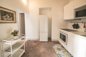 A compact kitchen with a refrigerator, oven, and a small countertop.