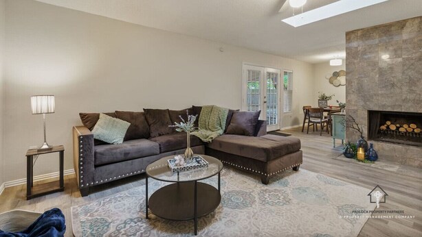 A living room with a sectional sofa, a round coffee table, a fireplace, and a ceiling fan. - AT&T, Globe Life, Six Flags - Updated Comfy Home (Grand Prairie)