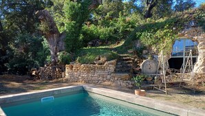A rectangular swimming pool with clear water, surrounded by a stone wall and lush greenery. - Eco-friendly house in a quiet location, one hour from the ocean  (Salernes)