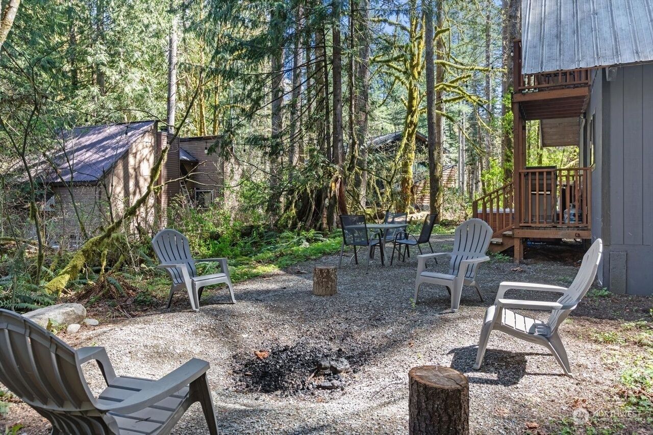A rustic cabin with a fire pit and outdoor seating.