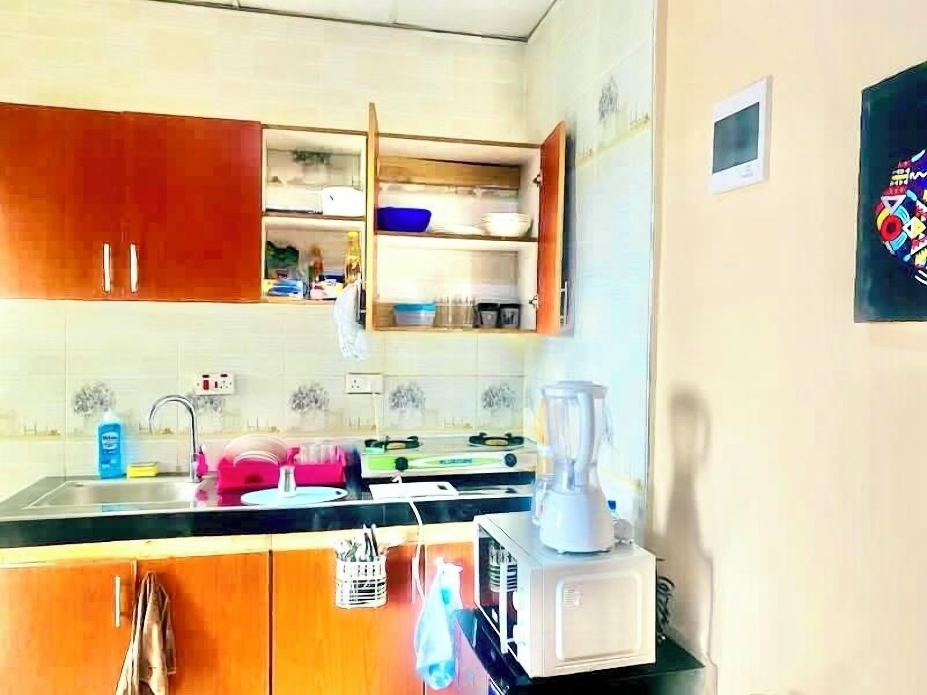 Una cucina con armadietti in legno, un lavello, un frullatore e una finestra sopra il bancone.