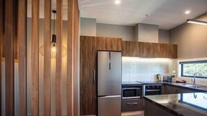 Eine moderne Küche mit Holzausstattung, Edelstahlgeräten und einer großen Kochinsel.