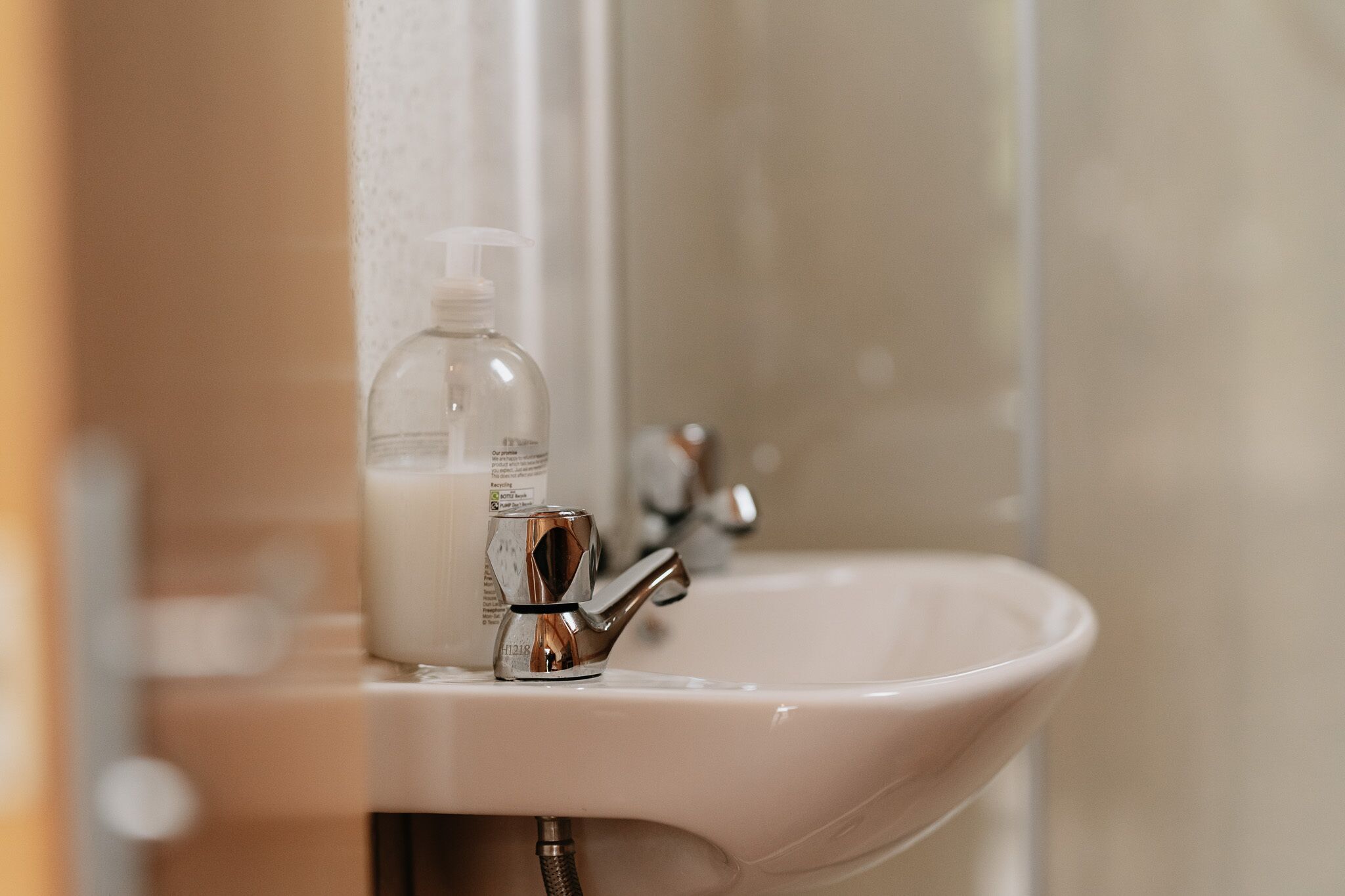 Un lavabo de salle de bain avec un robinet chromé et un distributeur de savon.