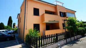 A two-story building with a flat roof and a balcony on the upper floor. - Apartment With Scenic View (Porec)