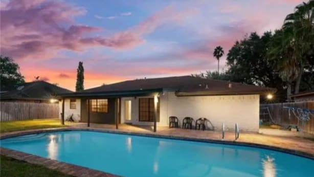 A residential property with a swimming pool, a covered patio, and a small attached garage. - Charming 3-bedroom house in lovely McAllen with AC, WiFi, Swimming pool. (McAllen)