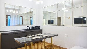 A modern kitchen with a large island, built-in appliances, and a flat-screen TV.