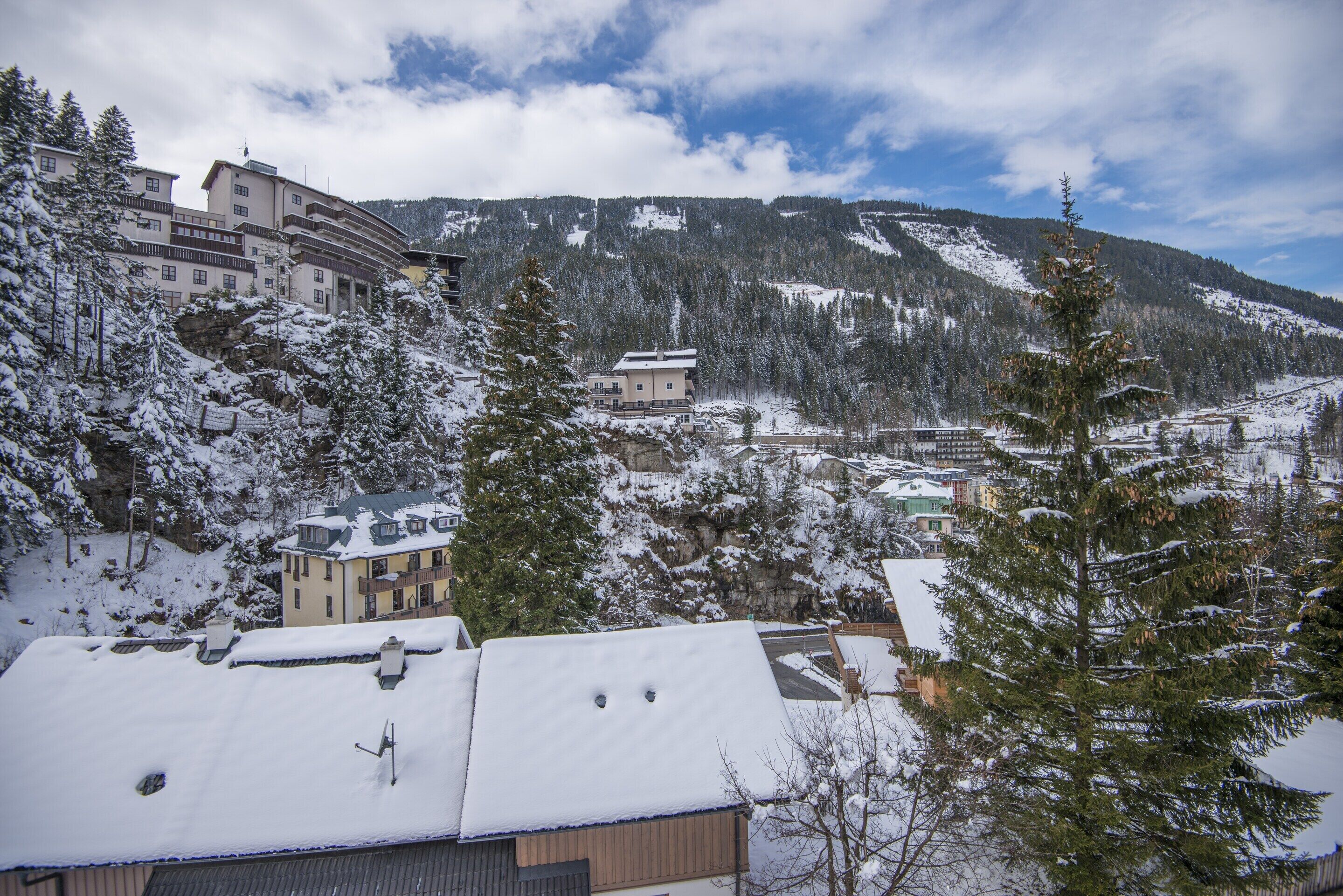 A snow-covered mountain village with traditional buildings and a prominent lodge.