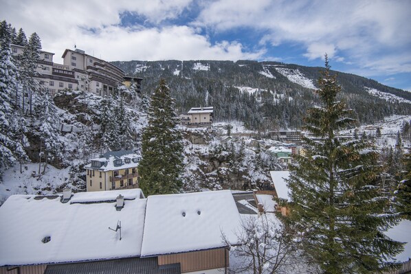 Un pueblo montañoso cubierto de nieve con edificios tradicionales y un albergue destacado.