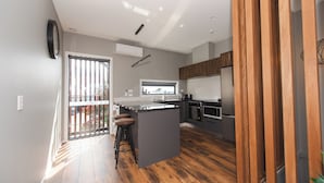 Una cocina moderna con una isla grande, suelo de madera y vistas al exterior.