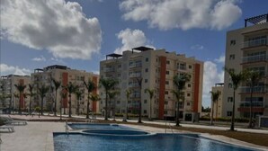Una piscina con cielo azul despejado y nubes al fondo.