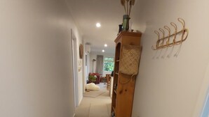 A wooden floor hallway with a dog walking towards the camera. - Ruru at Ligar Bay (Ligar Bay)