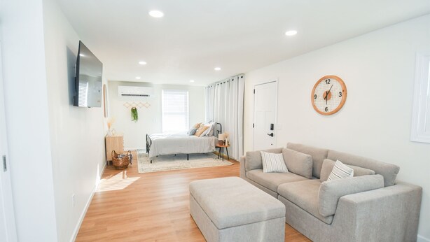 A modern, well-lit room with a bed, a sofa, and a television. - Boho Studio Downtown Amish Country + Scenic Views (Walnut Creek)