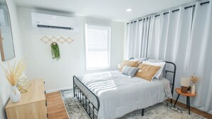 A bedroom with a bed, bedside table, and a window with blinds. - Boho Studio Downtown Amish Country + Scenic Views (Walnut Creek)