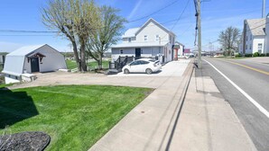 A residential street with houses, a parked car, and a clear sky. - Luxury Honeymoon Suite Amazing Views Amish Country (Walnut Creek)