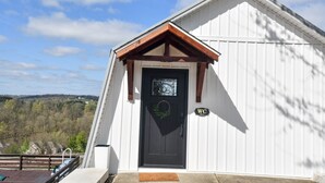 A white building with a black door, a 'WC' sign, and a 'Welcome' mat. - Luxury Honeymoon Suite Amazing Views Amish Country (Walnut Creek)