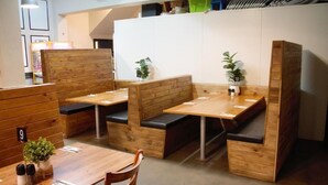 A modern interior with wooden furniture and built-in seating areas. - The Caledonian Hotel (Wonthaggi)