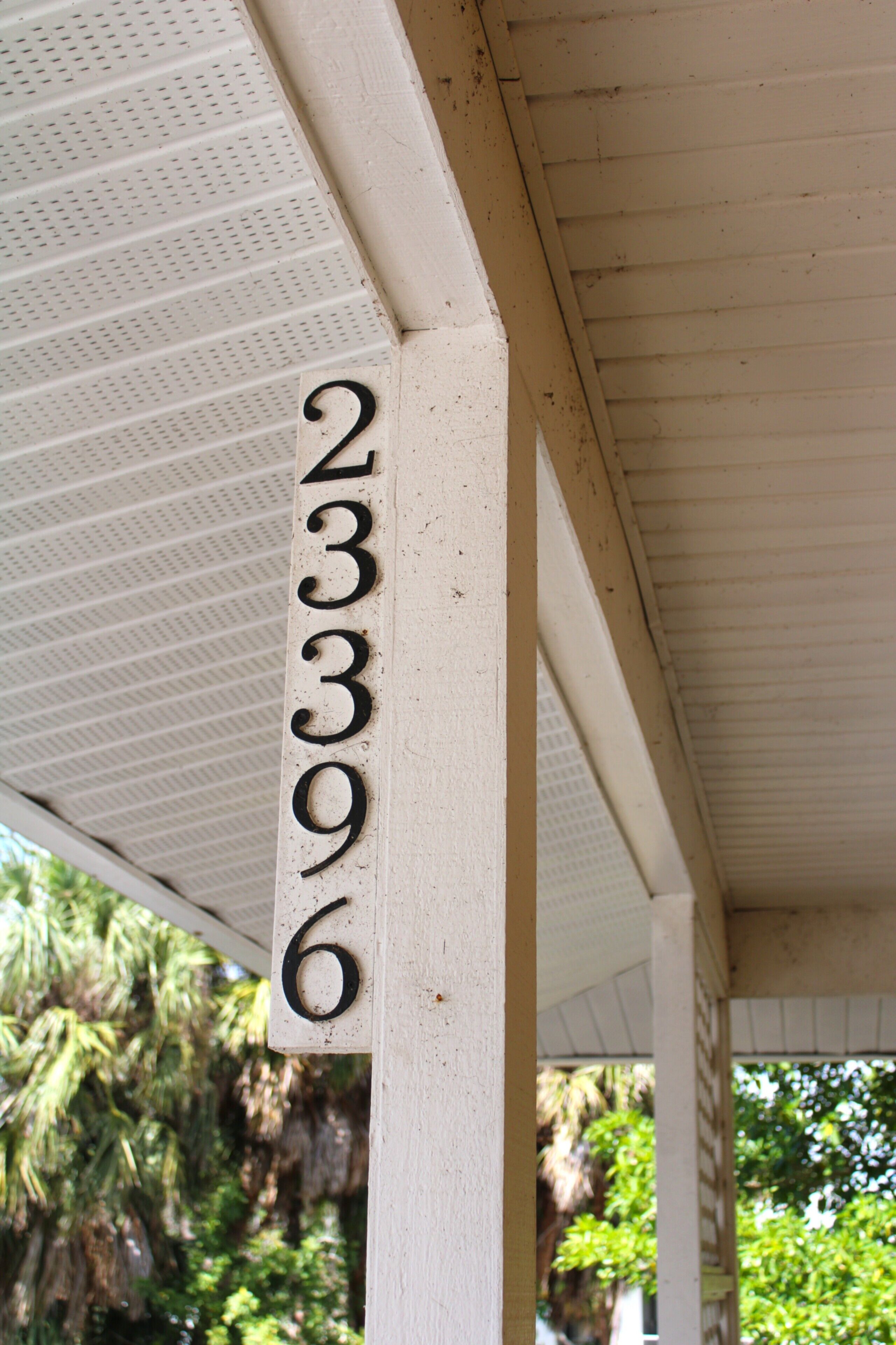 A white building with a number '23396' on a post.