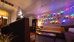 Un salon confortable avec un canapé, une table basse et une bibliothèque.
