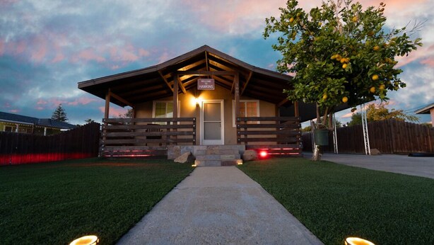 Un chalet doté d’une enseigne accueillante, d’un porche abrité et d’une pelouse bien entretenue.