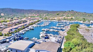 A marina with numerous boats docked, surrounded by residential buildings and greenery.