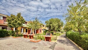 A courtyard with outdoor seating, surrounded by buildings with balconies and greenery.