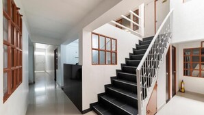 A modern staircase with black steps and white railings, leading to an upper floor. - Casa Fortel, Centro Internacional (Bogotá)