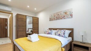 Ein Schlafzimmer mit einem Bett, einem Nachttisch, einem Spiegel und einem Bild an der Wand.