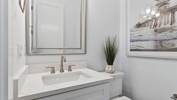 A bathroom with a white sink, a large mirror, and a framed photograph on the wall. - 3 Blocks to Beach Sleeps 19 Pool, Spa & Golf Cart in Gulf Place (Santa Rosa Beach)