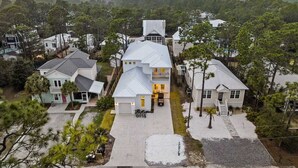 Uma área residencial com várias casas, incluindo uma casa de destaque com uma entrada ampla e garagem.