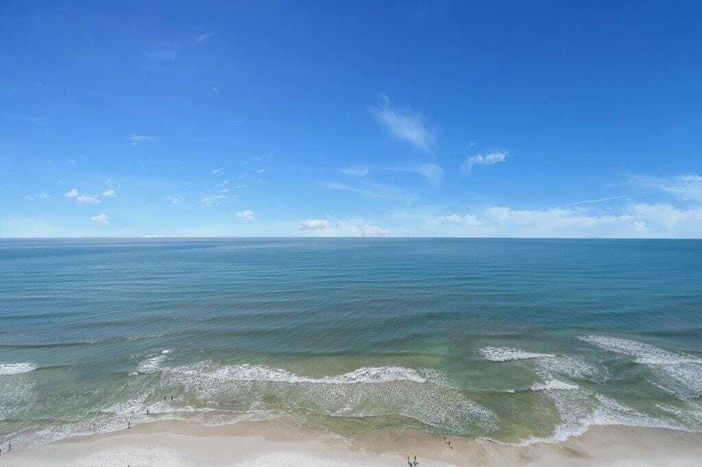 Una playa con agua azul cristalina y una orilla arenosa.