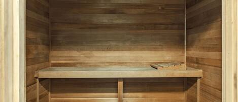 A wooden interior with a bench and a small table.