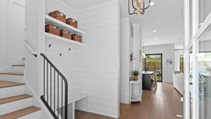 Een modern interieur met een trap, witte muren, houten vloer en manden op planken.