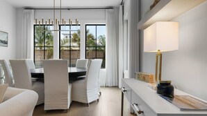 Een moderne eethoek met een tafel, stoelen, een lamp en uitzicht op de omgeving.