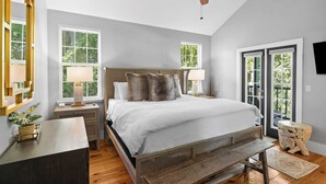 A bedroom with a bed, bedside tables, a ceiling fan, and large windows. - Coastal Soul 393 by Avantstay Near Boat Ramp & Bay, Private Yard (Santa Rosa Beach)