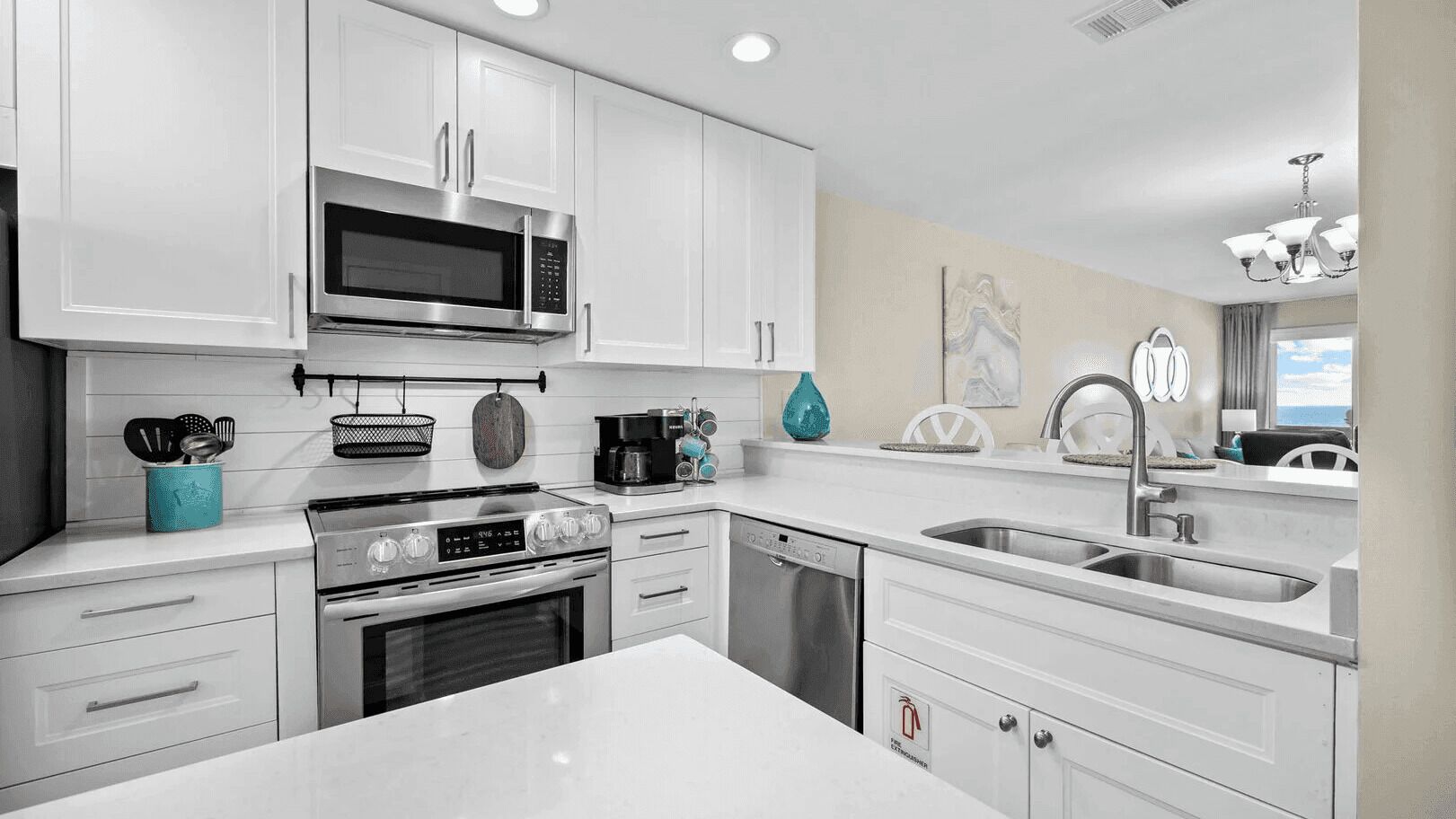 Una cocina moderna con armarios blancos, electrodomésticos de acero inoxidable y una isla grande.