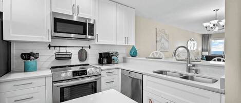 Una cocina moderna con armarios blancos, electrodomésticos de acero inoxidable y una isla grande.