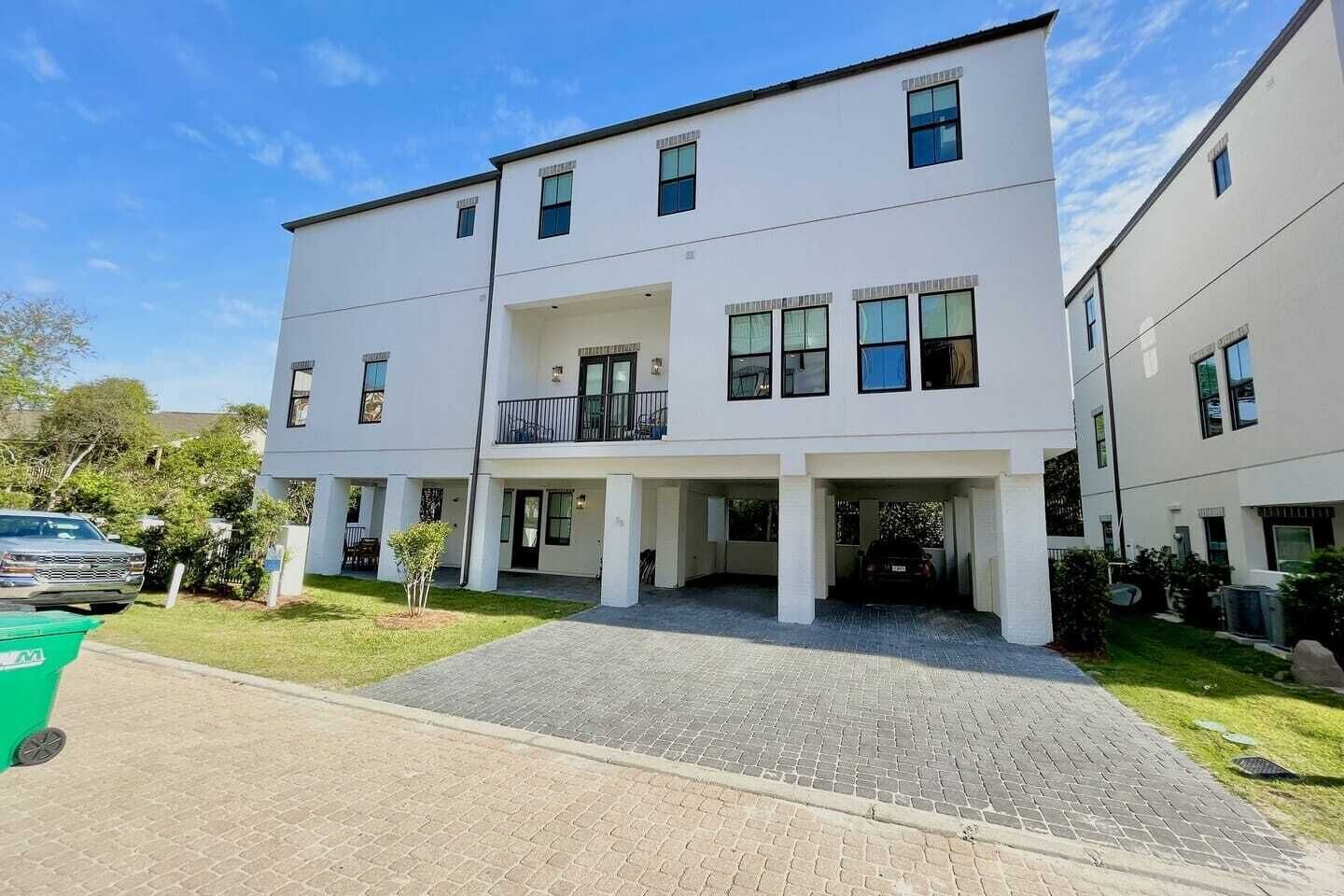 Un immeuble d’appartements moderne à deux étages, doté d’une entrée abritée et d’un petit balcon.