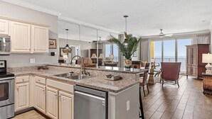 A spacious kitchen with granite countertops, stainless steel appliances, and light wood cabinets. - Bahama Breeze by Avantstay Gulf Front, 2 Pools, Beach Chairs Included! (Panama City Beach)