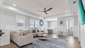 A spacious living room with a sectional sofa, a coffee table, and a large rug.