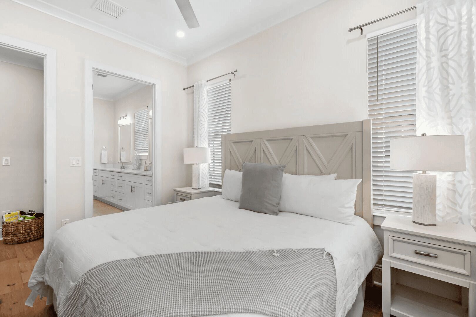 A bedroom with a large bed, a nightstand, a dresser, and a mirror.