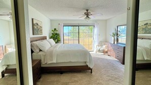 A bedroom with a large bed, a ceiling fan, and a view through a window. - PETS STAY FREE! 2 bed/2.5 ba townhome on Golf Course in the Foothills of Yuma (Yuma)