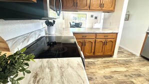 A kitchen with wooden cabinets, a marble countertop, and a black stove. - PETS STAY FREE! 2 bed/2.5 ba townhome on Golf Course in the Foothills of Yuma (Yuma)