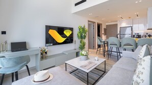 A modern living room with a sofa, coffee table, and a TV mounted on the wall. - Vogue 7 mins Sky Dubai 3 mins Cirle Mall (Dubai)