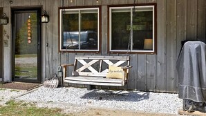 A wooden building with a bench, a covered grill, and a welcome sign. - Killington condo 5 min to killington resort (Killington)